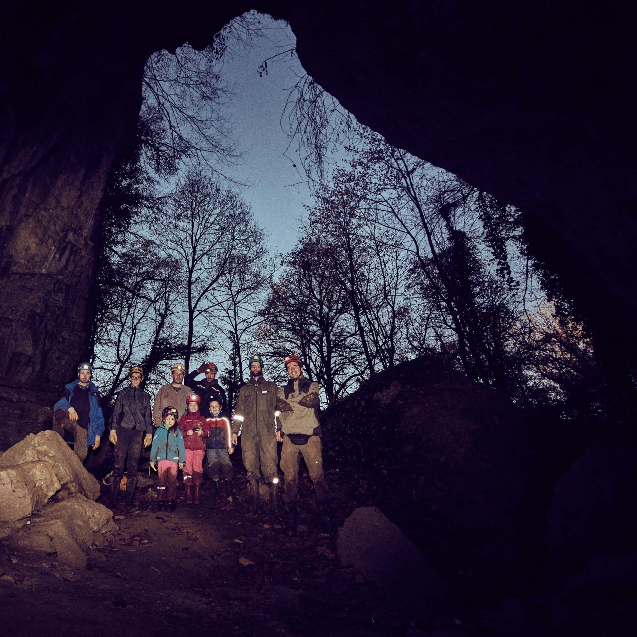 Tourteilnehmer nach der Höhlentour mit verschmutzten Klamotten vor dem Höhleneingang